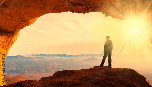 A man in mainsails and caves, sunset photo