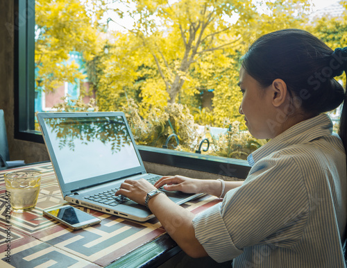 image of a young woman working on his laptop in a coffee shop, rear view of business woman hands busy using laptop at office desk, young woman student typing on computer sitting at table