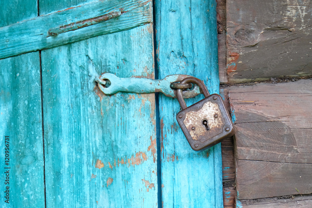 closed old rusty padlock on a wooden door. closed old rusty padlock on a wooden door.