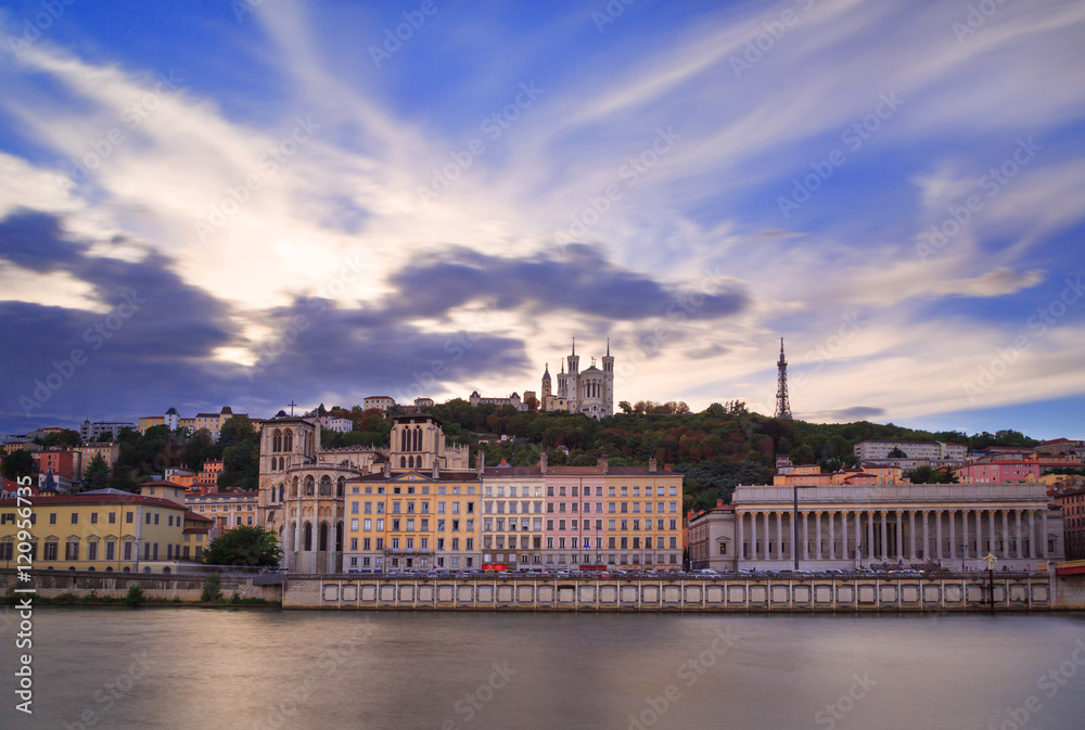 Colorful sunset at Vieux Lyon and Fourviere Basilica seen from the riverbank of the Saone, Lyon.