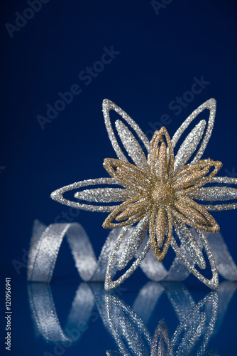 Christmas holiday snowflake and silver ribbon on dark blue background