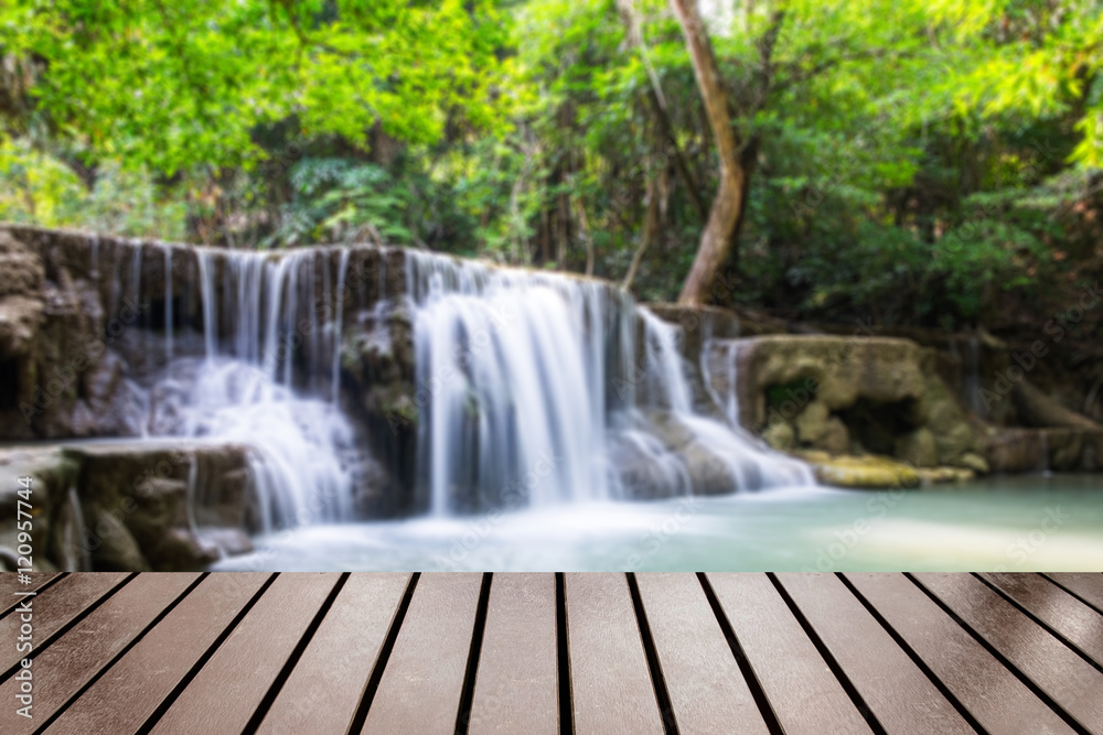 Wood table top on blurred waterfall tropical rain forest