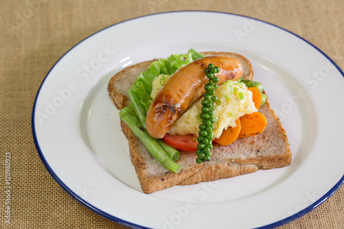American breakfast, sausage and bread with vegetables in white d