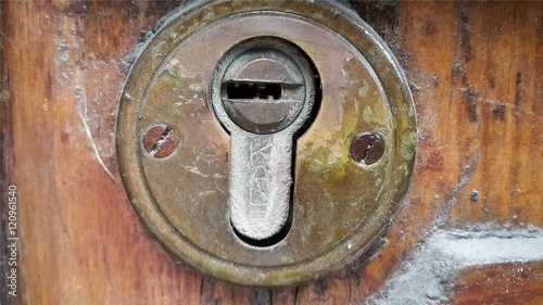 Old keyhole decorative element on wooden surface