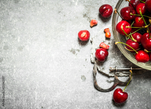 Red cherry in the Cup and metal tool for cherries.