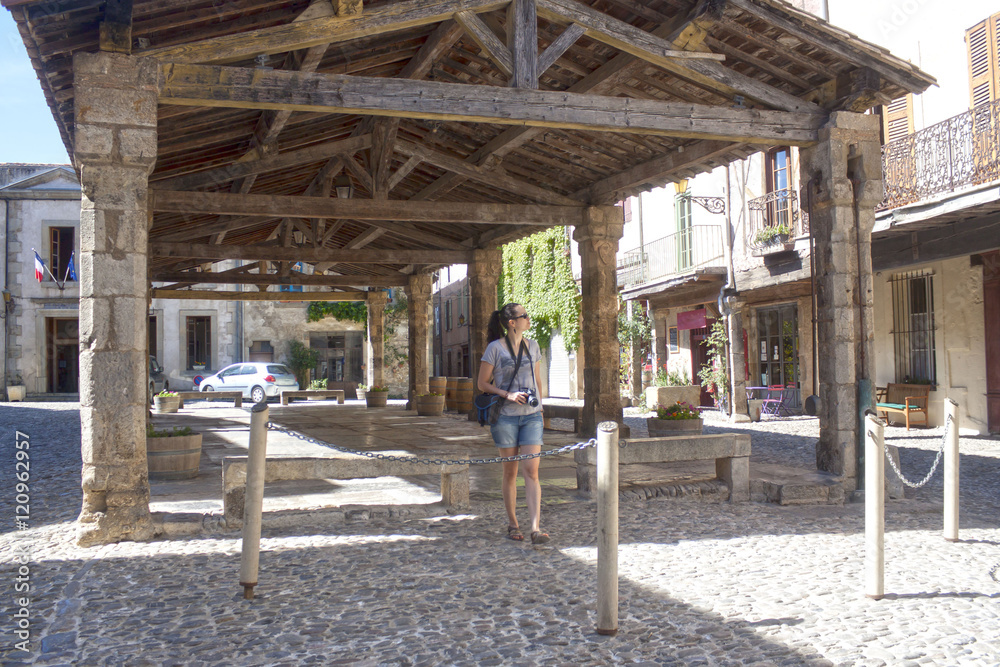 Photographer walking under a porch in Lagrasse, France Photographer walking under a porch in Lagrasse, France