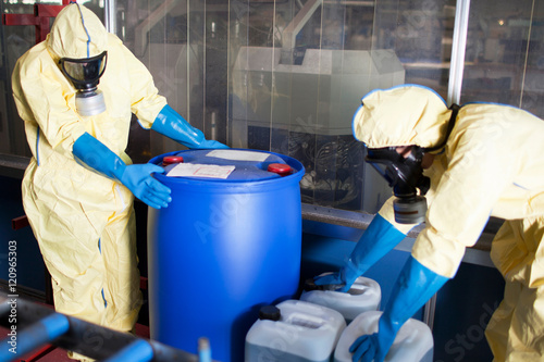 Workers in protective suits with toxic waste