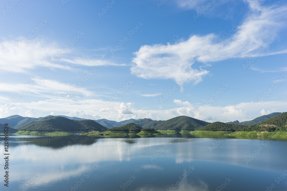 the blue skies and mountain reflected in a lake