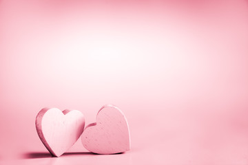 Two pink hearts on a pink background