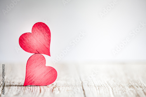 Two red hearts on wooden background