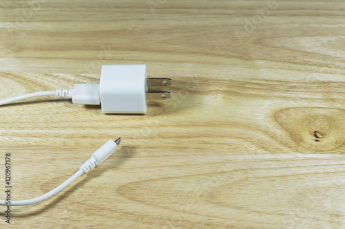 USB cable power adapter on wooden background.