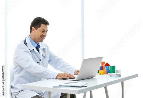 Pediatrician working at his...