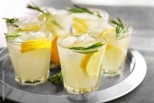 Cold fresh cocktail with lemon on metal tray