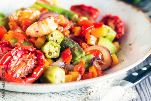 Vegetable stew with okra and shrimps in rustic composition – close up view