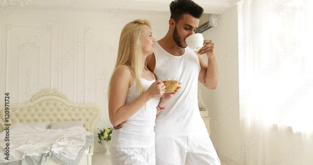 Couple drink coffee morning near window mix race man woman smile Couple drink coffee morning near window mix race man woman smile