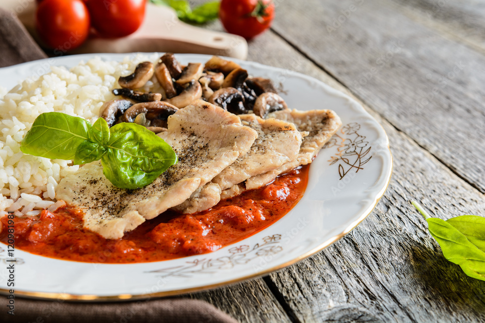 Fried pork cutlets with rice, tomato and mushrooms Fried pork cutlets with rice, tomato and mushrooms