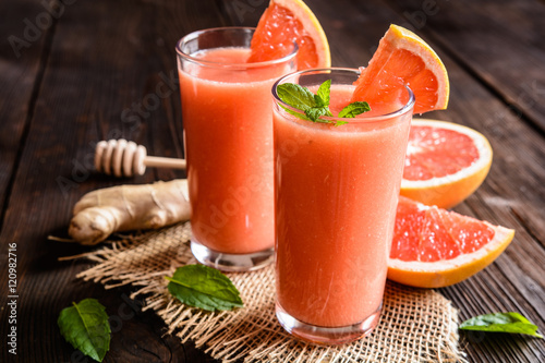 Grapefruit smoothie with ginger root and honey in a glass jar