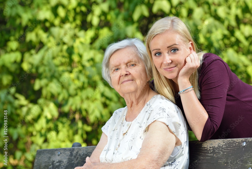 Grandmother and granddaughter. Young woman carefully takes care