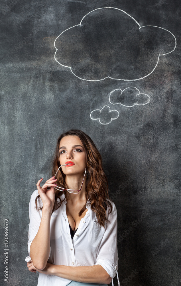 young attractive thoughtful woman near blackboard with blank think cloud