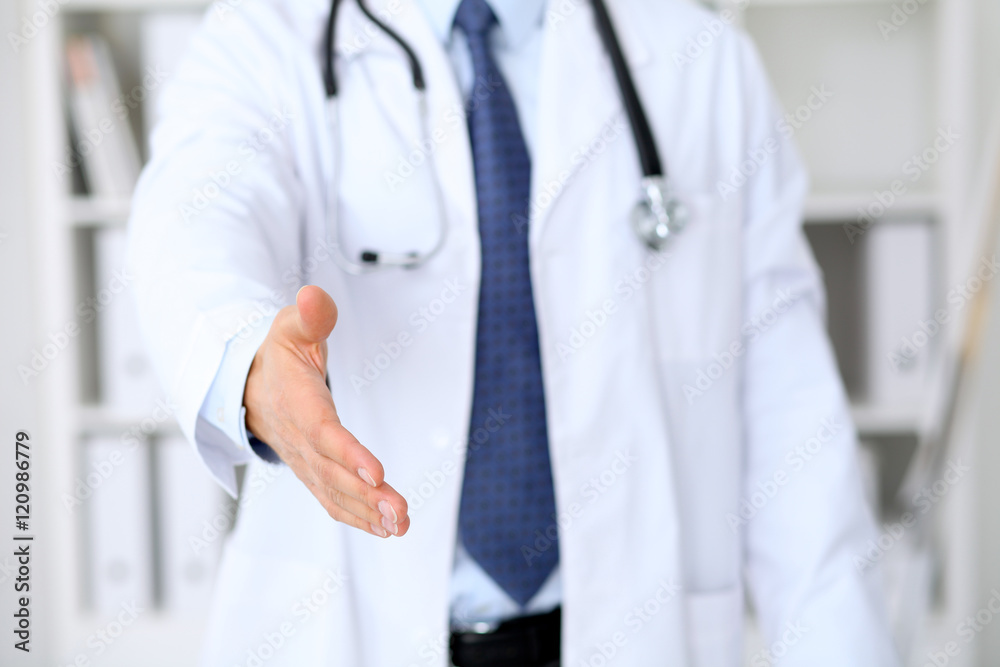 Male medicine doctor offering helping hand for handshake. Partnership and trust concept. Male medicine doctor offering helping hand for handshake. Partnership and trust concept.