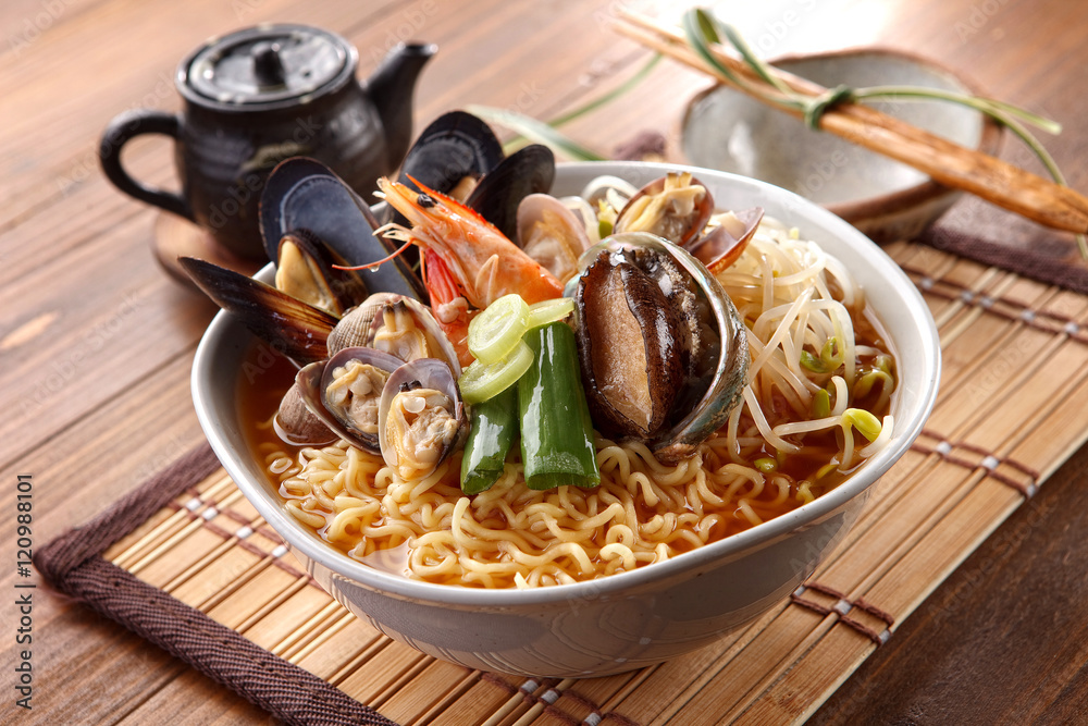 Big bowl of instant noodle with abalone, shrimp, clams, onion an Big bowl of instant noodle with abalone, shrimp, clams, onion an