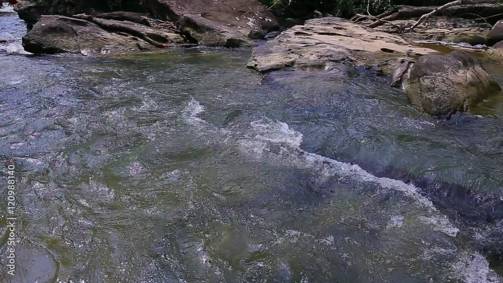Whitewater flowing over rocks in small river in thailand Whitewater flowing over rocks in small river in thailand