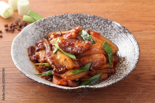 Plate of stewed pork with onion and green bean on the table photo