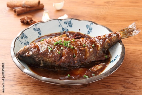 Photography Fried fish on chinese plate on wooden table in restaurant