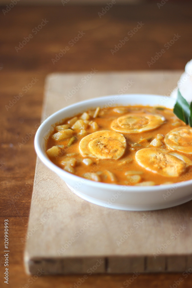 Indian style of Kerala egg curry recipe on wooden cutting board Indian style of Kerala egg curry recipe on wooden cutting board