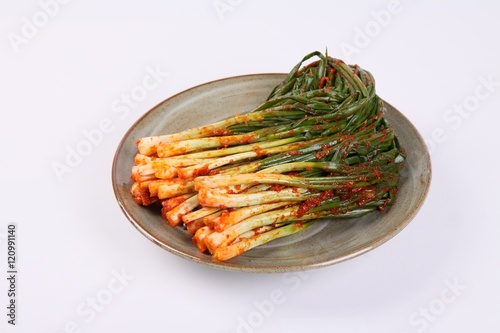 Korean green onion kimchi on plate on white background