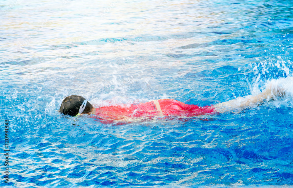 A boy swimming in the pool.Children's zone for swimming course.