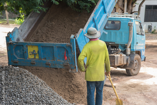 Dump truck unloading rock and soil at construction site