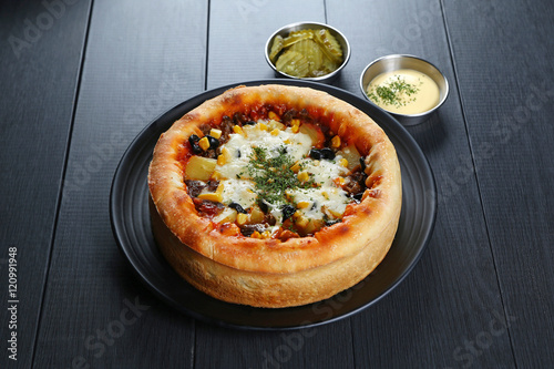 The seasoned chicago pizzza with meat, pineapple, corn, olives, photo