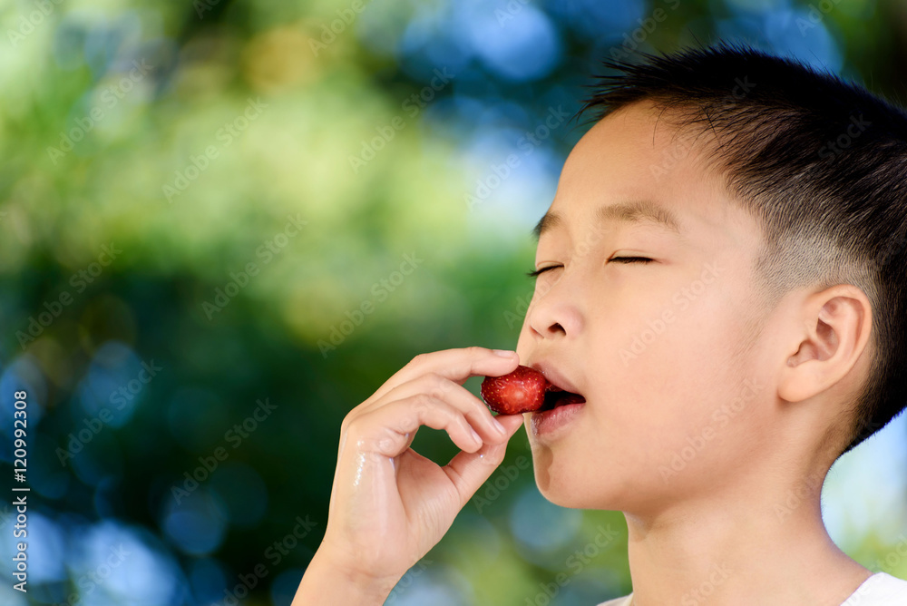 Boy eat strawberry