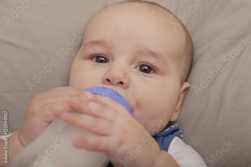Baby boy drinking milk from the bottle © tiagozr