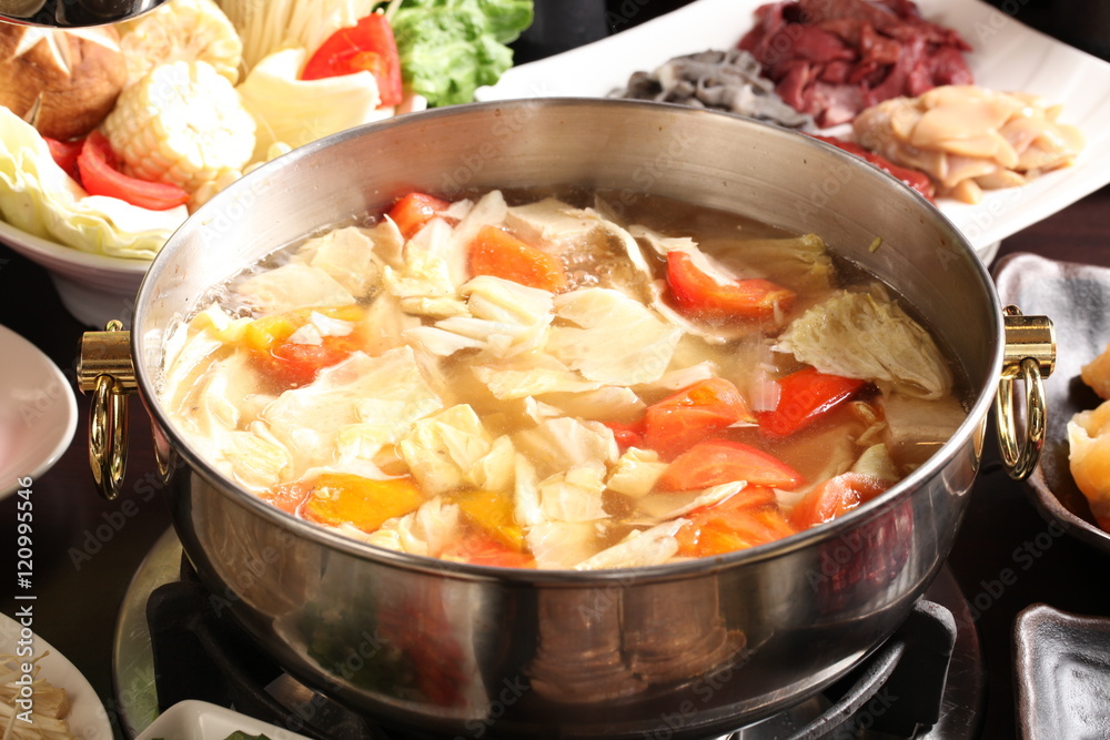 Vegetable hot pot with corn, cabbage, tomato, beef and pork in c