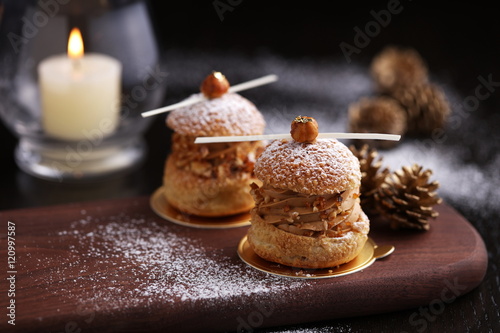 Praline hazelnut choux on wooden tray with pine for Christmas