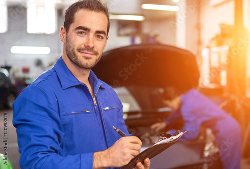 Young attractive mechanic working at the garage