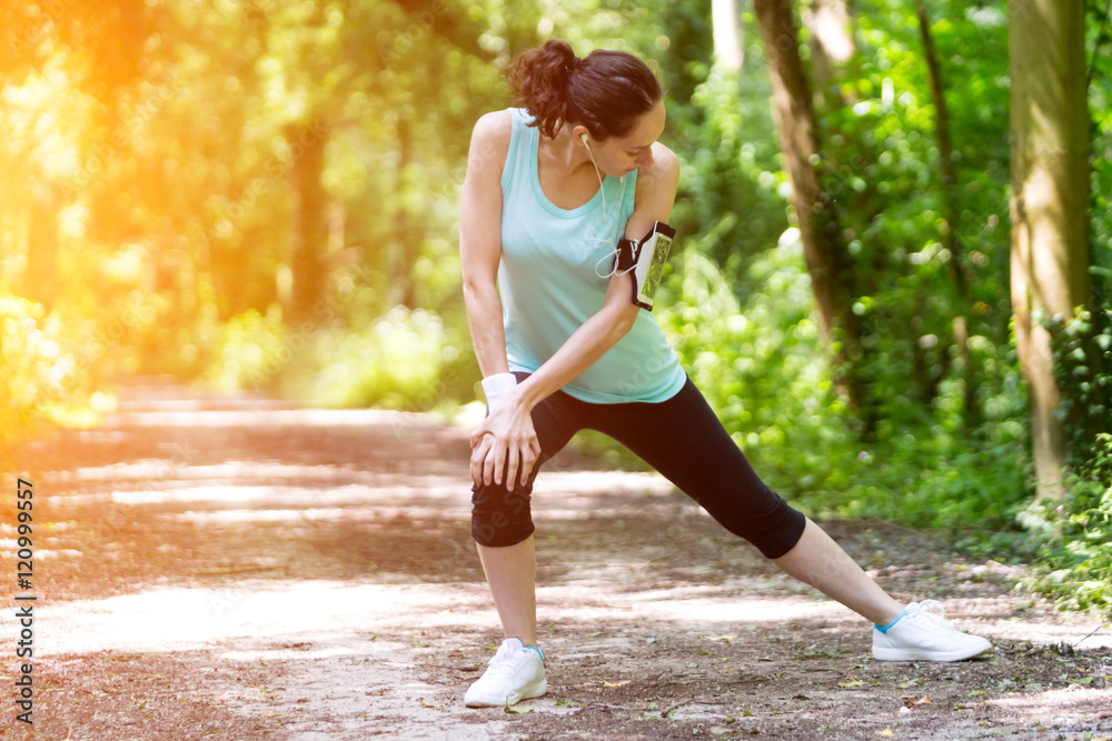 Young attractive woman stretching after a running session