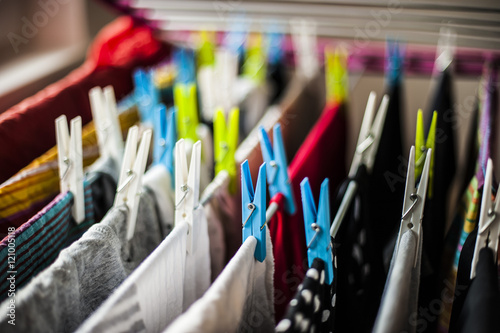abiti e vestiti appesi ad asciugare con le mollette colorate photo