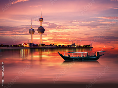 An old Arabian boat docked in front of Kuwait Landmark