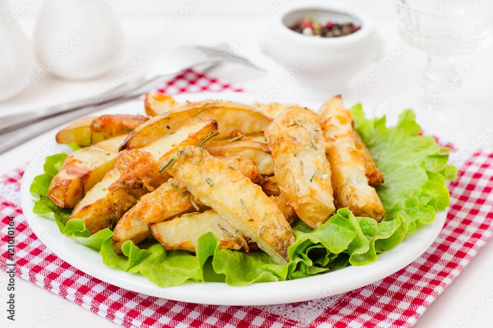 Fried sliced potatoes with lettuce on white plate in restaurant Fried sliced potatoes with lettuce on white plate in restaurant