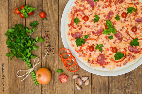 Pizza with sausage and cheese, cherry tomatoes and peppers in th