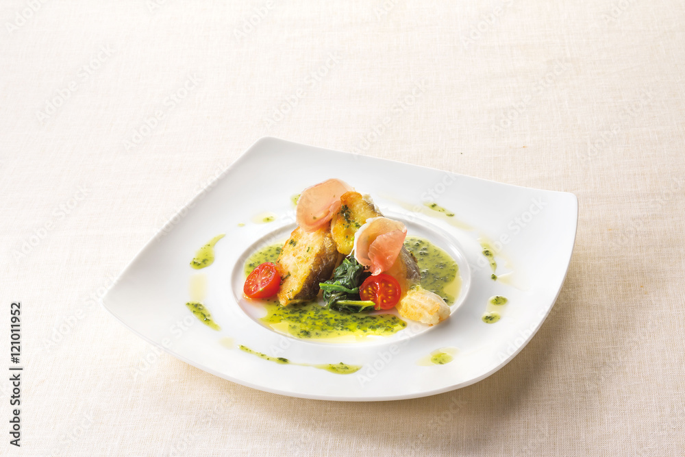 Poiret basil butter sauce of white fish on white plate backgroun Poiret basil butter sauce of white fish on white plate backgroun