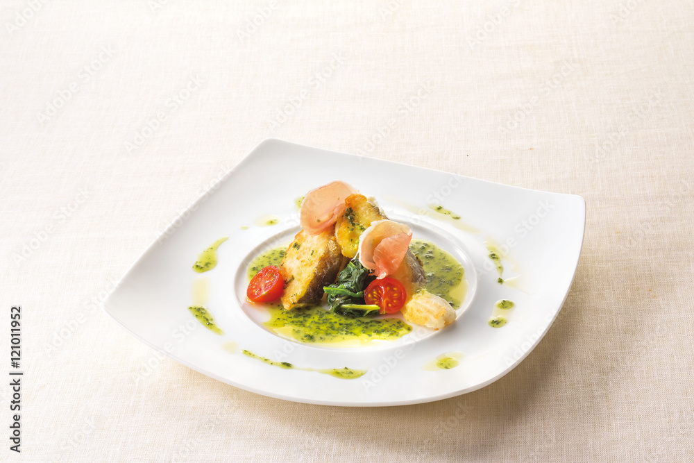 Poiret basil butter sauce of white fish on white plate backgroun