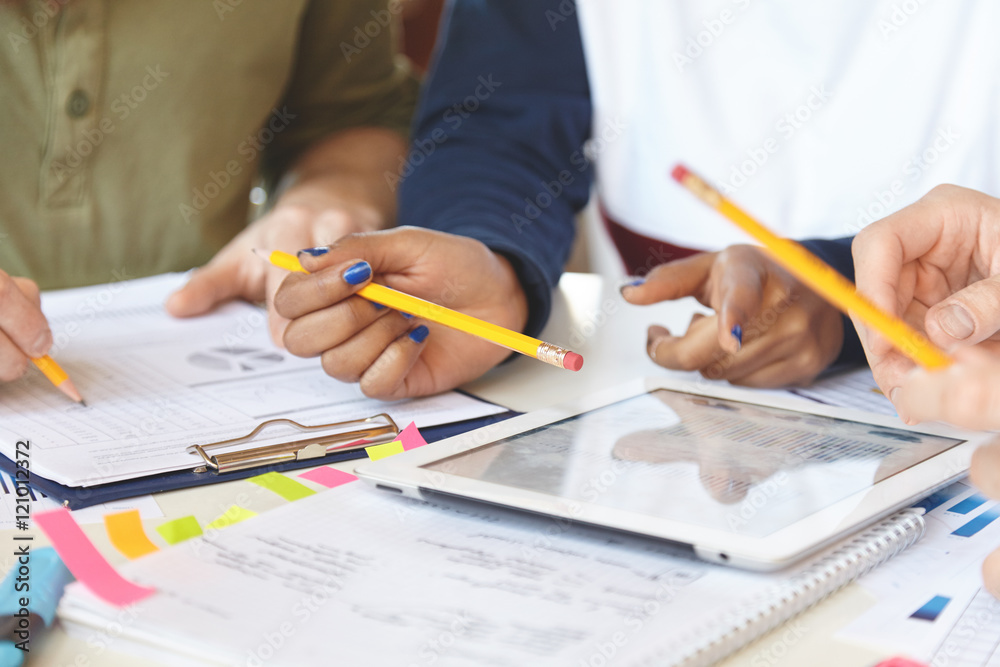 Hands of three colleagues studying annual financial report at office, using pad with copy space screen for your promotional text, analyzing statistics date, counting loss and profit in percentage