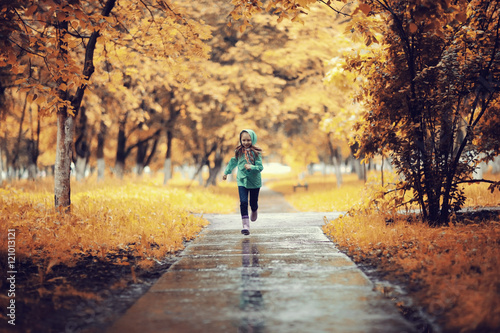 Girl 6-7 runs in the autumn park