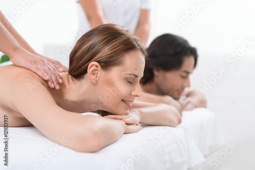 Happy couple getting massage at spa