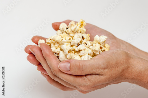 Female hand with popcorn on a white background