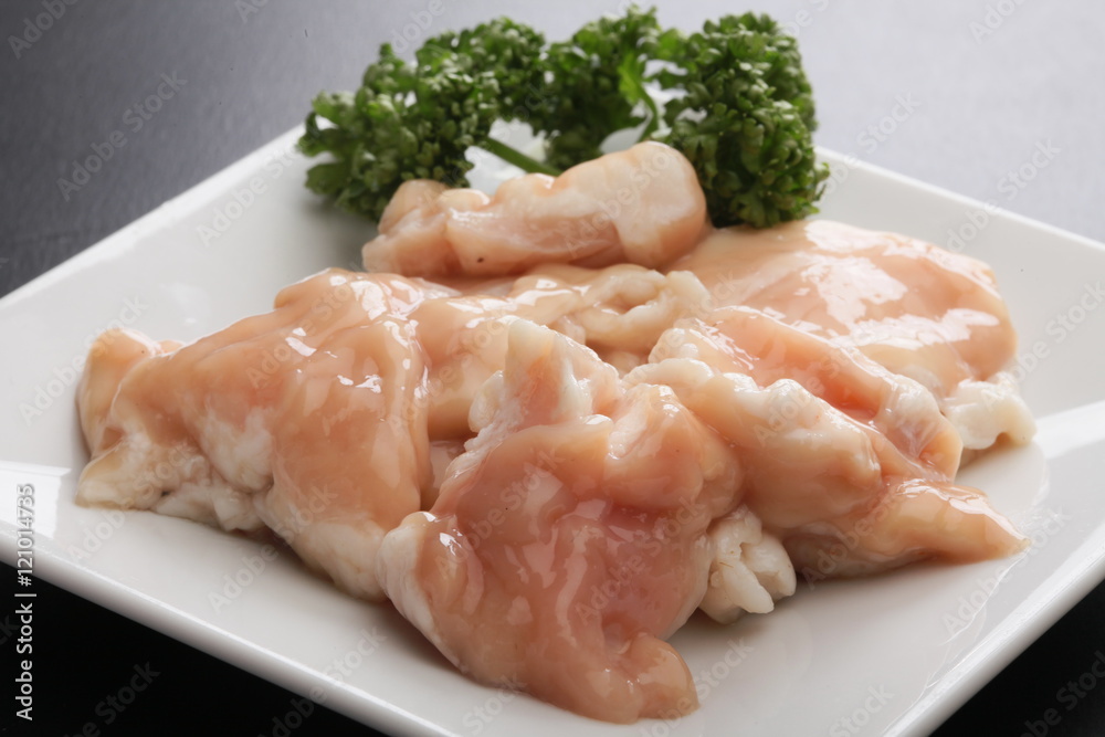 Specialty fresh salt hormone pig stomach with cumin on white pla Specialty fresh salt hormone pig stomach with cumin on white pla